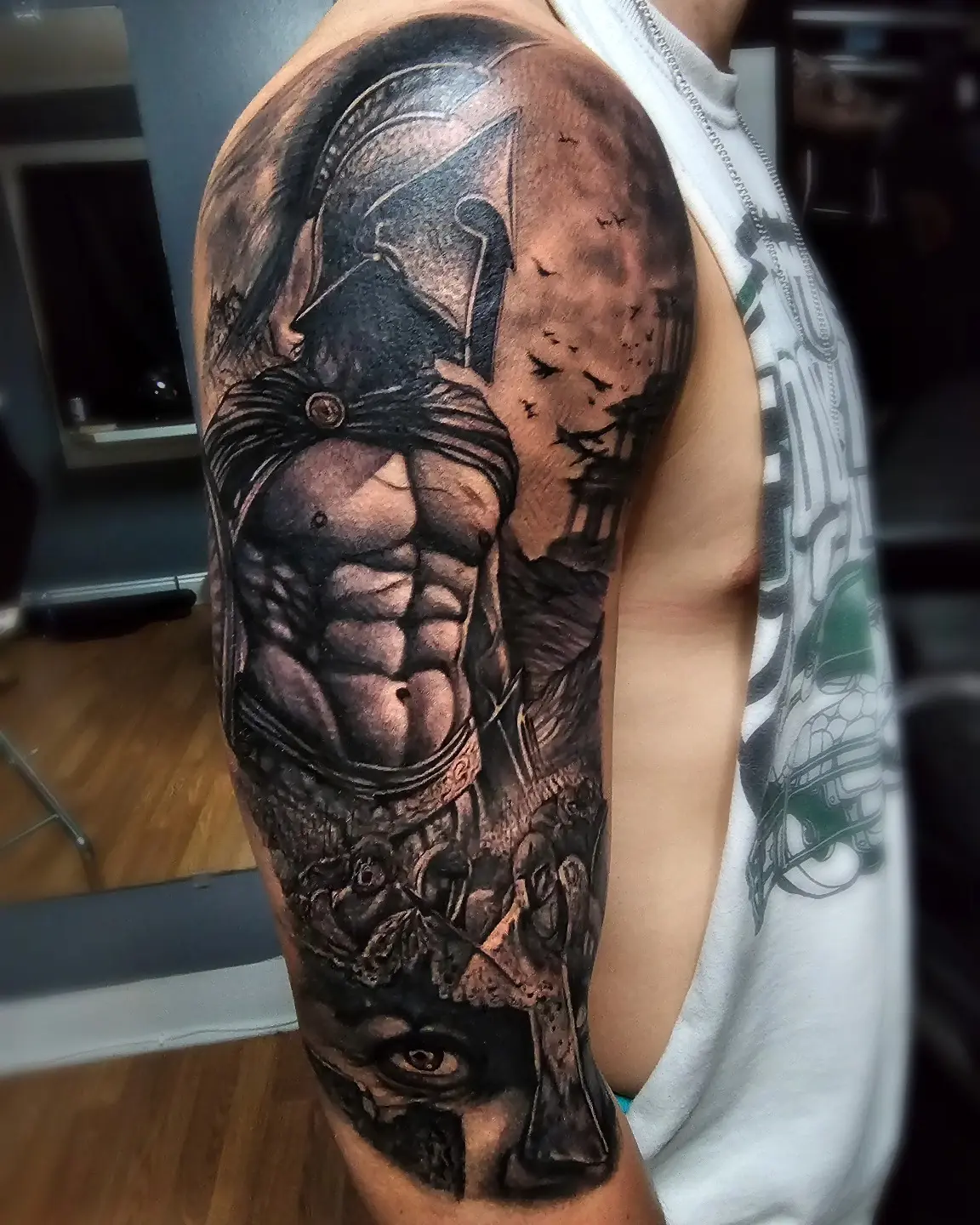 Black and grey neo-traditional Spartan warrior upper-arm sleeve with battlefield scene by Joel at Shadow Studio Charlotte